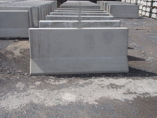 Shorter precast concrete traffic barriers standing in the yard