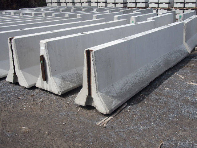 Precast concrete traffic barriers with end connectors standing in rows