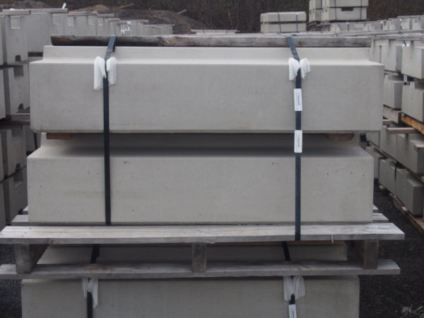 Precast rail-platform curb base components stacked on a pallet